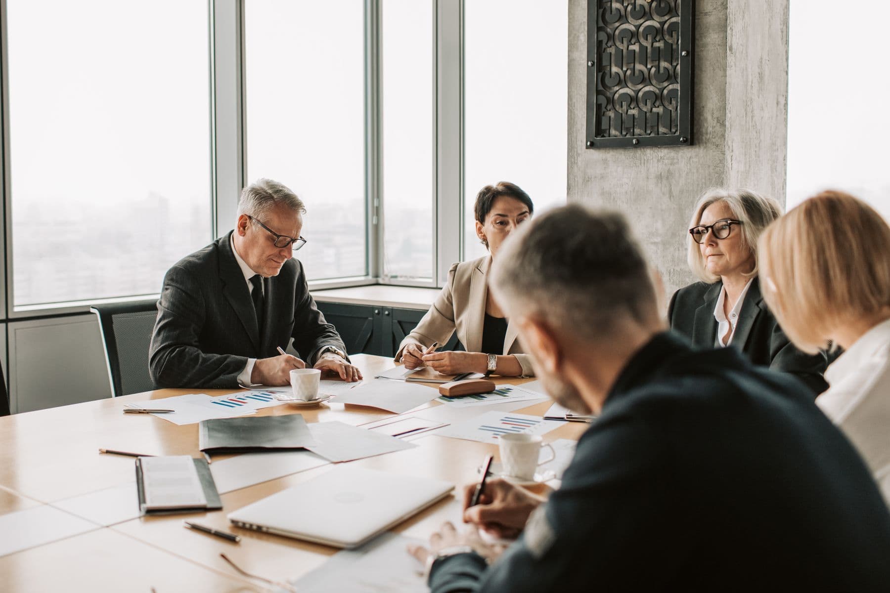 Professionals meeting around a conference table in daylight.